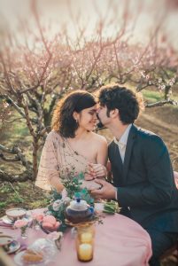 Romantic couple enjoying intimate outdoor picnic in blooming orchard