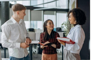 Three colleagues talking and smiling in modern office