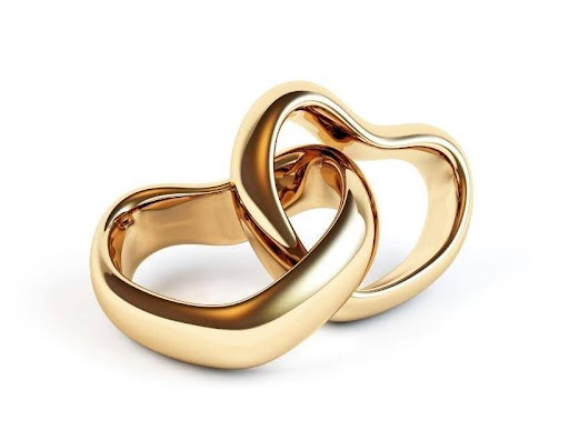 Two intertwined gold wedding rings on a white background